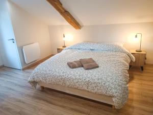 ein Schlafzimmer mit einem Bett mit zwei Handtüchern darauf in der Unterkunft Le gîte d'Ouillon in Saint-Hostien