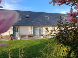 a house with a yard with flowers in front of it at Gîte des 3 marcassins in Préaux