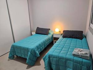 a room with two beds and a table with a lamp at Portal de Tupungato in Tupungato