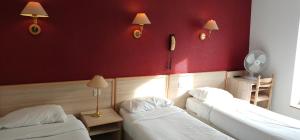 a room with two beds and a red wall at Hotel CÖRONA Lourdes in Lourdes