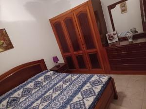 Schlafzimmer mit einem Bett und einem Holzschrank in der Unterkunft Repousando II in Ribeira Grande
