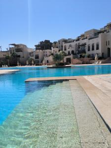 a swimming pool with blue water in front of buildings at Roof top apartment with panorama view in Hurghada