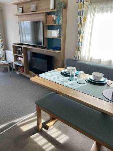a living room with a table and a tv at Hoburne Devon Bay - Hot Tub 2 Bed Paignton in Paignton +40 photos