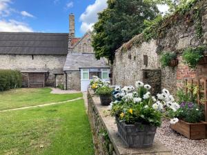 an old stone house with flowers in a yard at The Old Abbey Farmhouse - Pet Friendly in Ryde