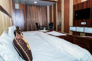 Cette chambre comprend un grand lit et une télévision. dans l'établissement Akash Wani Home Stay, à Rishikesh
