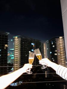 two people holding glasses of champagne on top of a building at Staycation in the Corner by MJJ in Manila