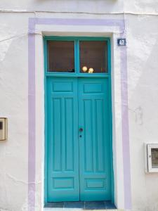 une porte bleue sur un bâtiment blanc avec une fenêtre dans l'établissement TheharmonyhouseTaganana, à Taganana