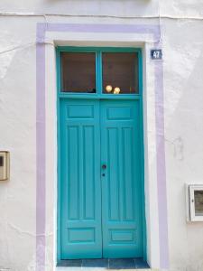 a blue door on a white building with a window at TheharmonyhouseTaganana in Taganana
