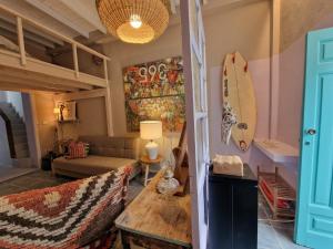 uma sala de estar com um sofá e uma prancha de surf na parede em TheharmonyhouseTaganana em Taganana