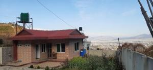 uma pequena casa de tijolos com telhado vermelho em Small house in boshan kathmandu em Dakshīnkāli