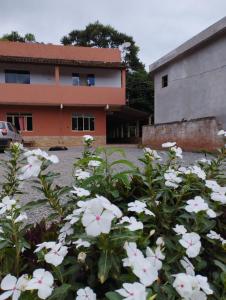 a bunch of white flowers in front of a building at Casa da Vó Bia in Alto Caparao