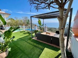 a garden with a view of the ocean from a house at SeaHomes Vacations, LA CASA BLUE Mediterranean Lifestyle in Blanes