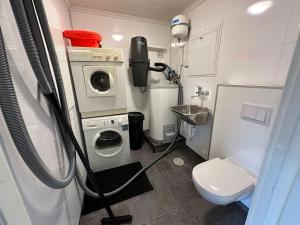 a small bathroom with a washing machine and a toilet at Rorbu i Gilsvågen - Egen Brygge - Båtutleie in Blænes