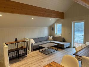 a living room with a couch and a table at Rorbu i Gilsvågen - Egen Brygge - Båtutleie in Blænes +13 photos