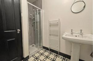 une salle de bains avec douche, lavabo et miroir dans l'établissement Beside West Strand beach Portrush Ground Floor Apartment, à Portrush