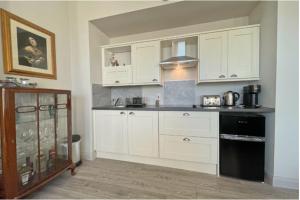 une cuisine avec des armoires blanches et un four noir dans l'établissement Beside West Strand beach Portrush Ground Floor Apartment, à Portrush