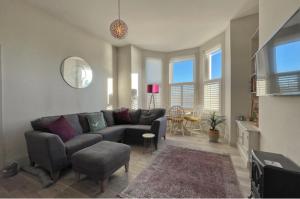 un salon avec un canapé et une table dans l'établissement Beside West Strand beach Portrush Ground Floor Apartment, à Portrush