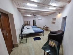 een kamer met een bed en een bank erin bij The Red Soil Country in Siuri