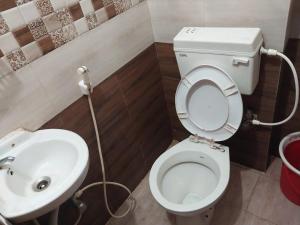 La salle de bains est pourvue de toilettes et d'un lavabo. dans l'établissement Hotel Madison Patia Inn Bhubaneswar, à Bhubaneswar