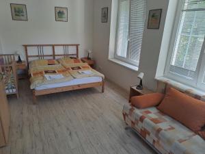 1 dormitorio con 1 cama, 1 sofá y 2 ventanas en Ferienhaus für 12 Personen und 3 Kinder in Vranov, Böhmen 