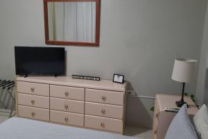Un dormitorio con un tocador con TV. en Coamo Beautiful house, AC, 10min Coamo hot springs, en Coamo