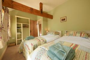 two twin beds in a room with atained at Spring Cottage in Kendal