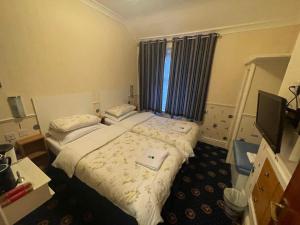 a hotel room with two beds and a television at THE WILFORD HOTEL in Blackpool