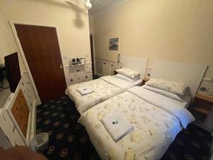 two beds in a hotel room with towels on them at THE WILFORD HOTEL in Blackpool +3 photos