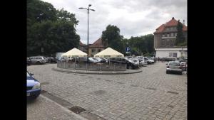 um parque de estacionamento com carros estacionados e tendas brancas em Spadzista 4 em Klodzko