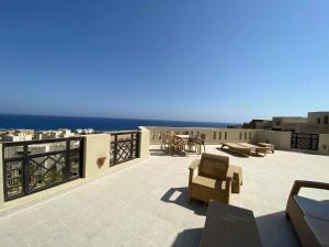 a patio with chairs and a view of the ocean at Roof top apartment with panorama view in Hurghada