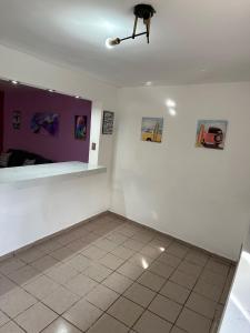 een kamer met een witte muur met schilderijen erop bij Habitación privada en casa compartida. in Tepic