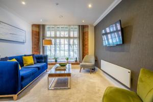 a living room with a blue couch and a table at 31 Cocoa Suites in York