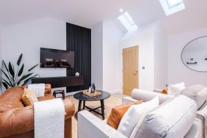uma sala de estar com mobiliário branco e uma televisão de ecrã plano em South Street Apartments em Hull