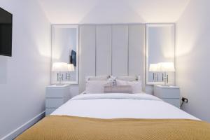 um quarto com uma grande cama branca e 2 candeeiros em South Street Apartments em Hull