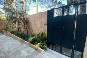 un portail bleu devant une clôture dans l'établissement Suite boutique Oyamel en Avándaro, Valle de Bravo, à Valle de Bravo