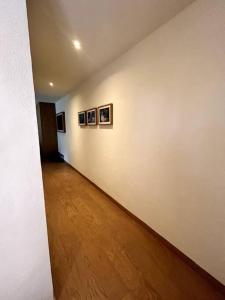 un couloir vide avec trois photos sur le mur dans l'établissement Suite boutique Oyamel en Avándaro, Valle de Bravo, à Valle de Bravo