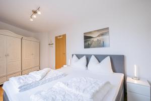 een slaapkamer met een groot wit bed met witte kussens bij Ferienwohnpark Immenstaad am Bodensee Zwei-Zimmer-Apartment 49 18 in Immenstaad am Bodensee
