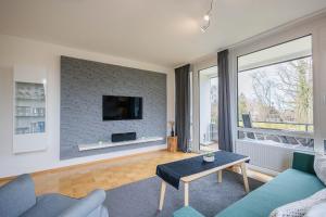 een woonkamer met een bank en een tv aan een bakstenen muur bij Ferienwohnpark Immenstaad am Bodensee Zwei-Zimmer-Apartment 49 18 in Immenstaad am Bodensee