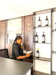 a woman sitting at a table with bottles of wine at BiggysPlace in Ijebu Ode