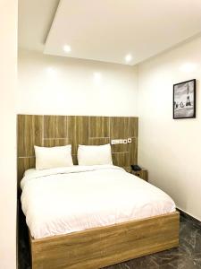 a bedroom with a bed with a wooden headboard at BiggysPlace in Ijebu Ode
