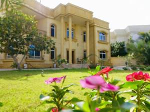 a large house with pink flowers in front of it at Villa Room #6 in Umm Al Sheif in Dubai