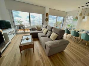uma sala de estar com um sofá e uma mesa em SeaHomes Vacations, LA CASA BLUE Mediterranean Lifestyle em Blanes