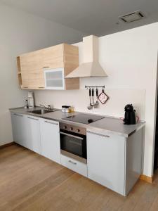 a kitchen with white cabinets and a stove top oven at Appartamento Loft in Turin