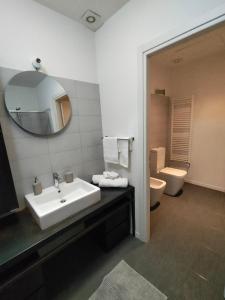 a bathroom with a sink and a toilet and a mirror at Appartamento Loft in Turin