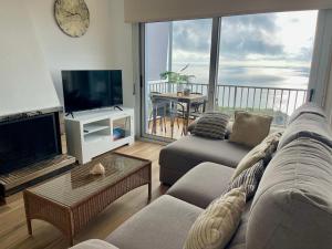 a living room with a couch and a flat screen tv at SeaHomes Vacations, LA CASA BLUE Mediterranean Lifestyle in Blanes