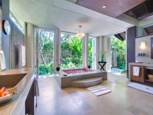 a bathroom with a tub and a large window at Villa Samadhana in Ketewel