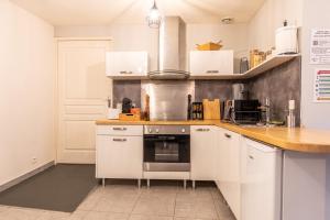 een keuken met witte kasten en een aanrecht bij Nid douillet - Elégant studio en plein centre de Riom in Riom