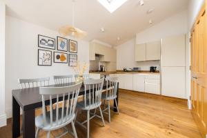 a kitchen and dining room with a table and chairs at The Tooting Hideout - Dazzling 3BDR Flat with Balcony in London