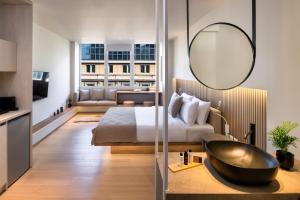 a hotel room with a bed and a mirror at Pelagus City - Luxury Suite I in Thessaloniki