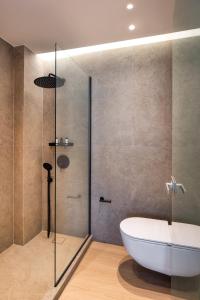a bathroom with a tub and a glass shower at Pelagus City - Luxury Suite I in Thessaloniki